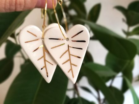 Cercei frunze albe, de iarnă, din ceramică, modelați și decorați cu aur. Închizătoare inox auriu. 3,2 x 7,5 cm. 8 g / perechea. Design Gruni