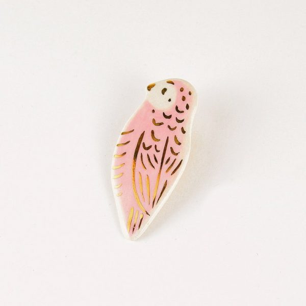 Broșă tip pin cu pasăre roz din ceramică decorată manual cu aur. Dimensiune 2,5 x 5,5 cm. Pin alamă pentru haine groase. Unicat. Gruni