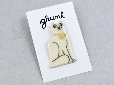 Broşă ceramică tip pin pisică albă, desenată manual cu negru. 3 x 5 cm, 7 g. Pin alamă. Potrivit pentru haine groase. Design Gruni.